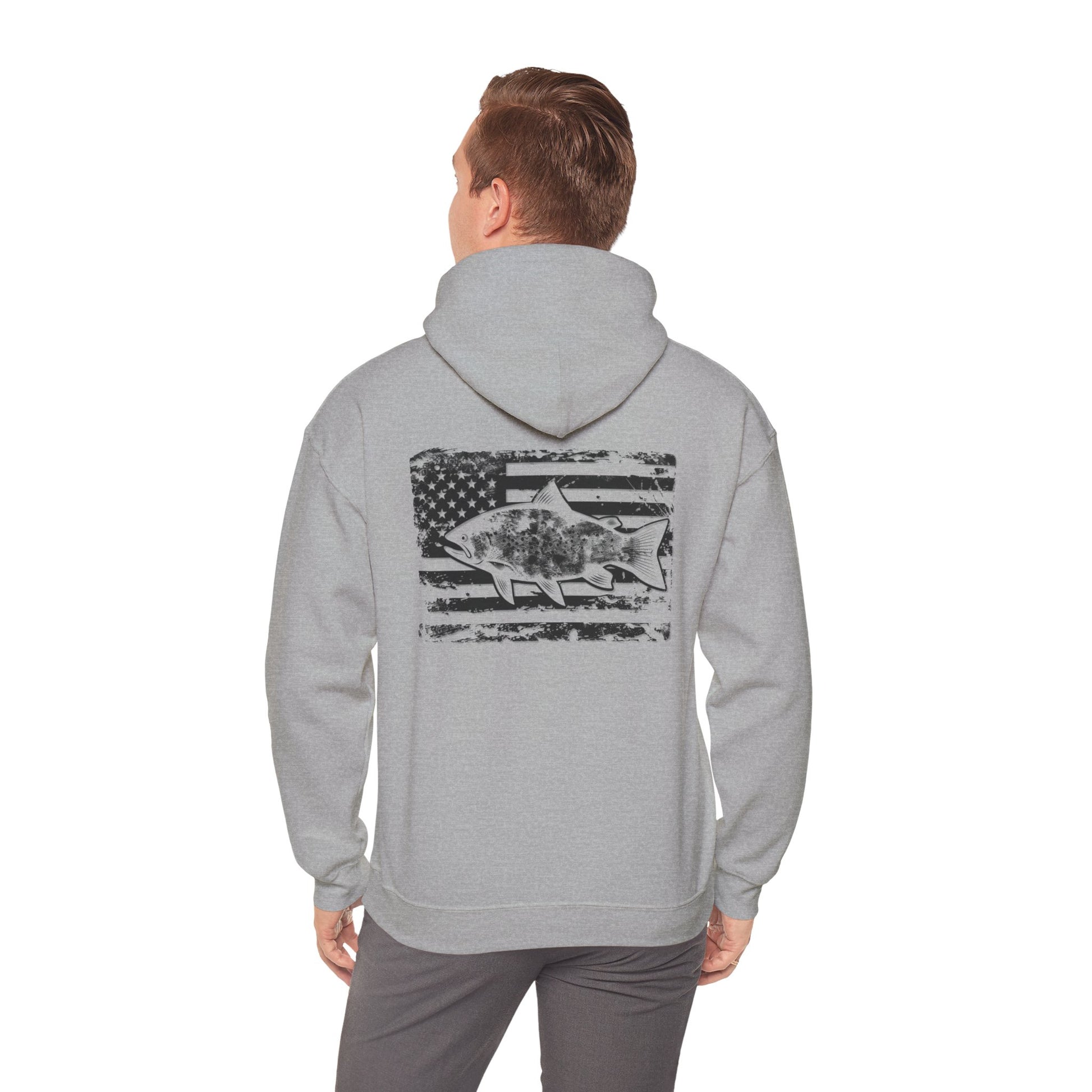 The Reeling In Freedom - Cotton/Poly Blend - Hoodie, ideal for any fishing enthusiast, is depicted from the front and back. The front showcases a small fish graphic accompanied by "Feeling of Freedom" text on the left chest, while the back prominently features a large fish graphic set against a distressed American flag design, celebrating American pride.