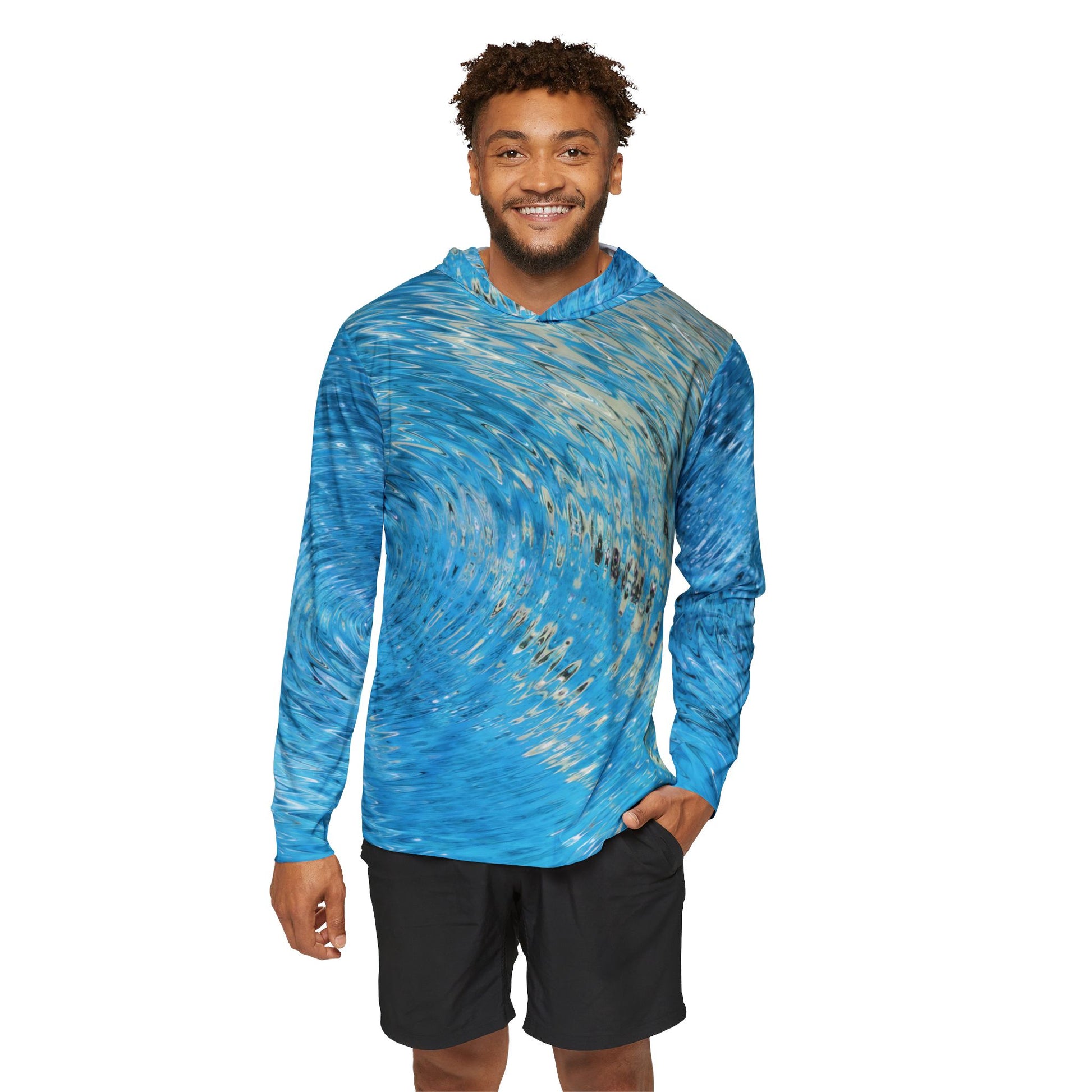 A person wearing the Water Ripples sun-protection hoodie in blue, featuring a bright blue and gold pattern with moisture-wicking polyester, and black shorts smiles at the camera against a plain white background.