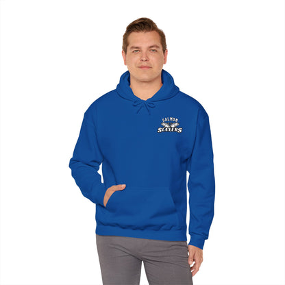 A man in a blue "Salmon Slayers - Twin Salmon Logo" unisex hoodie, made from an ethically sourced cotton/poly blend, stands against a plain white background with his hands in his pockets.