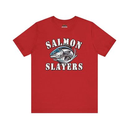 A blue unisex T-shirt made from 100% Airlume cotton featuring the text "Salmon Slayers" in bold, white, distressed letters. Below, an illustration of a fierce-looking fish with sharp teeth and dynamic lines suggests movement. Enjoy fast shipping on this striking design: **Slamon Slayers - Fierce Flash - T-Shirt**.