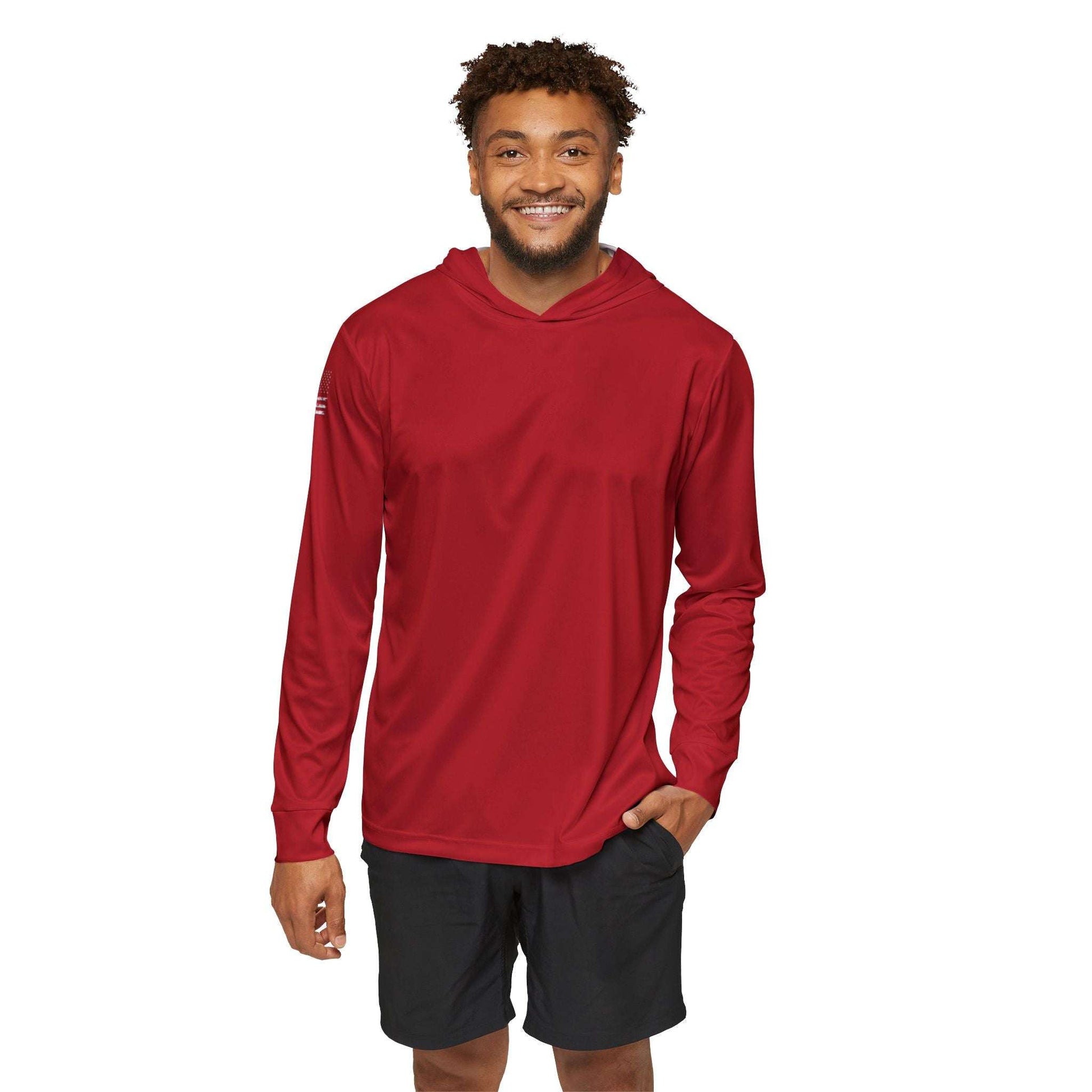 A person wearing a red Patriotic Sun Protection Long Sleeve with Hood UPF +50 and black shorts smiles for the camera against a white background, showcasing stylish fishing apparel with exceptional sun protection.