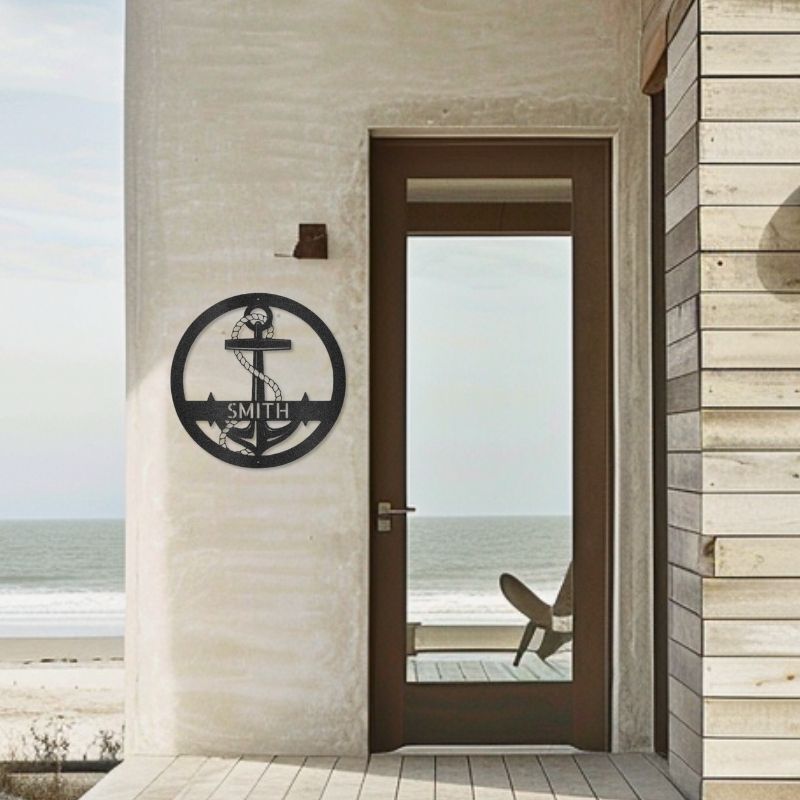 Customizable laser-cut steel anchor sign on beachside wall.