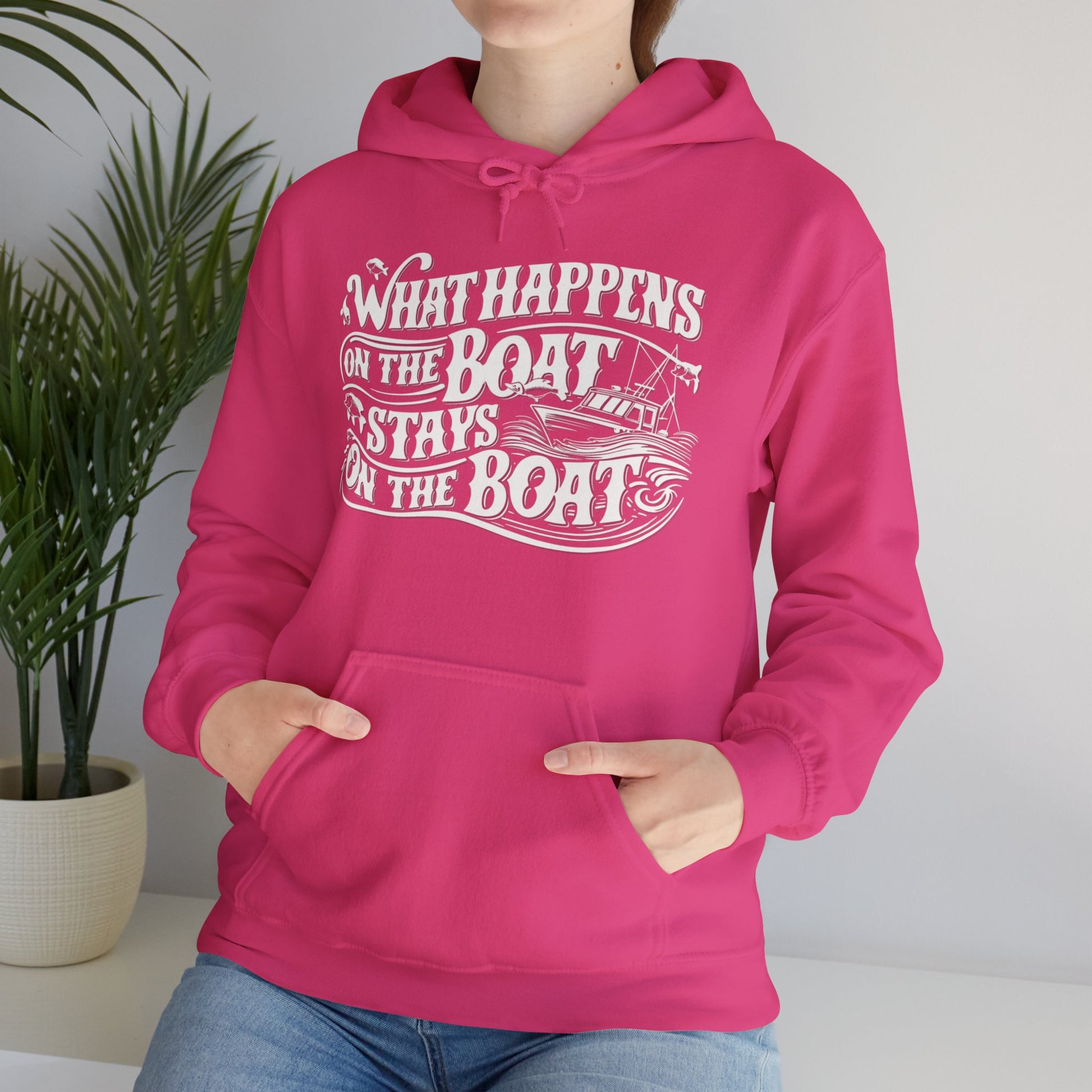 What Happens on the Boat, Stays on the Boat - Cotton/Poly Blend Hoodie - 7 Color Choices featuring white text that says "What Happens on the Boat Stays on the Boat" with fishing hooks and a boat illustration integrated into the design. The unisex hooded sweatshirt has a front pocket and drawstring hood, perfect for those with an adventurous spirit.