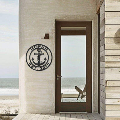 Customizable laser-cut steel Anchor Family Name sign on exterior wall by seaside door.