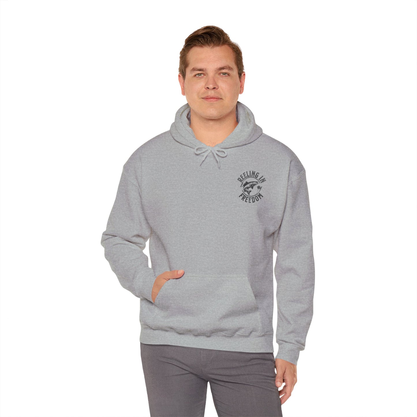 The Reeling In Freedom - Cotton/Poly Blend - Hoodie, ideal for any fishing enthusiast, is depicted from the front and back. The front showcases a small fish graphic accompanied by "Feeling of Freedom" text on the left chest, while the back prominently features a large fish graphic set against a distressed American flag design, celebrating American pride.