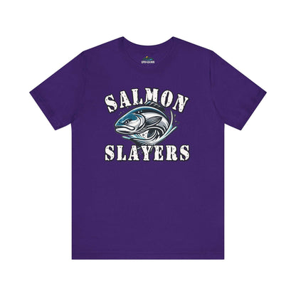 A blue unisex T-shirt made from 100% Airlume cotton featuring the text "Salmon Slayers" in bold, white, distressed letters. Below, an illustration of a fierce-looking fish with sharp teeth and dynamic lines suggests movement. Enjoy fast shipping on this striking design: **Slamon Slayers - Fierce Flash - T-Shirt**.