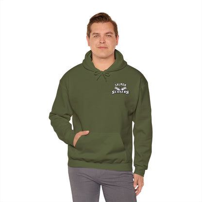 A person wears an olive green Salmon Slayers - Twin Salmon Logo - Cotton/Poly Blend Hoodie, featuring "Salmon Slayers" prominently on the chest. This unisex hoodie is styled with gray pants and set against a plain white background, hands tucked into the front pocket for a relaxed, casual look.