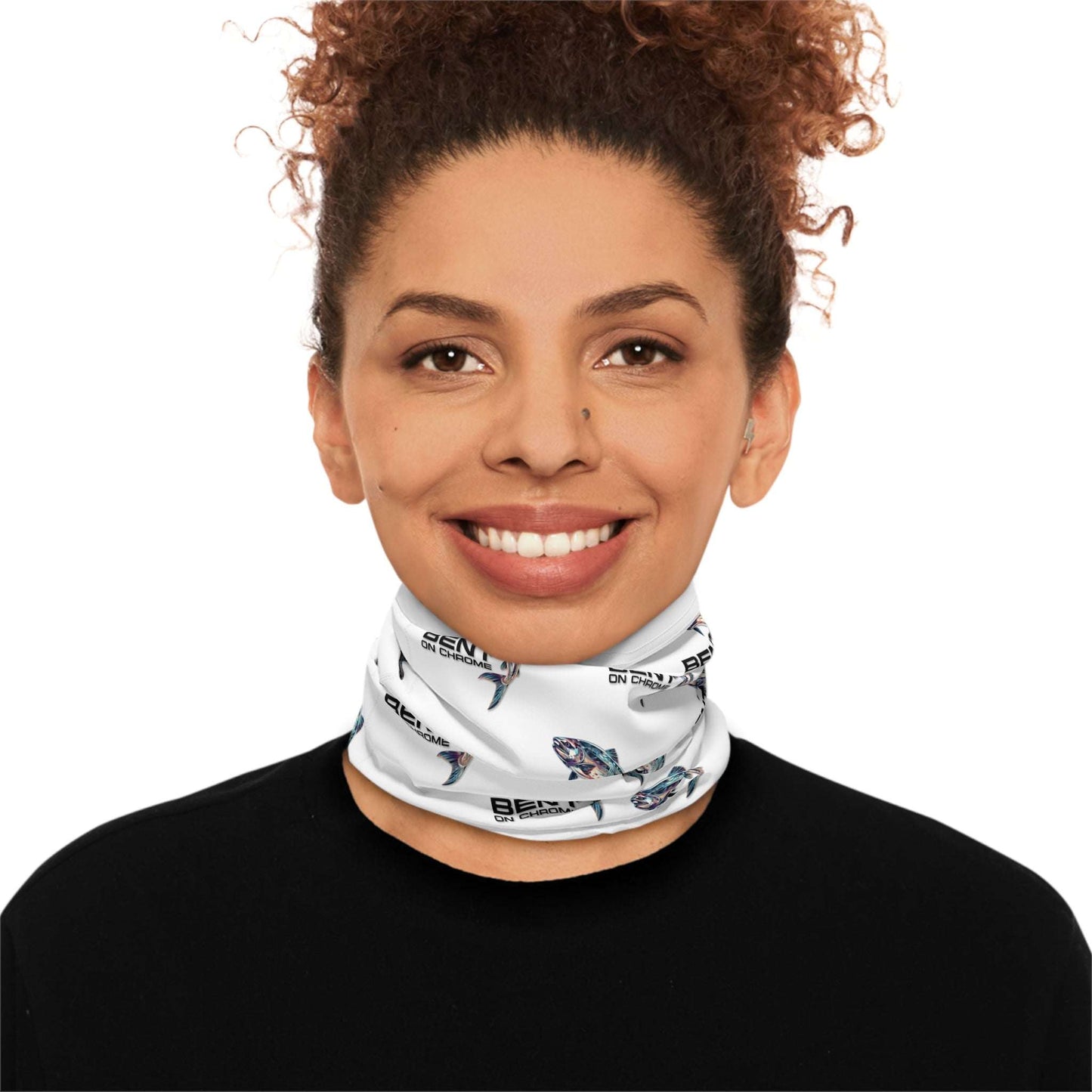 A woman with curly hair wearing a "Bent On Chrome - Lightweight Neck Gaiter" face mask with colorful abstract patterns, set against a neutral background. The mask covers her mouth and nose, branded with the "benti" logo.