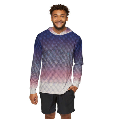 A person grinning, dressed in the Salmon Scales Sun Protection Long Sleeve with Hood, showcasing a blue to purple ombre scale pattern and paired with black shorts. This hoodie, made from moisture-wicking polyester, exhibits a textured fish-scale appearance and includes UPF 50+ protection as an added advantage against a white backdrop.