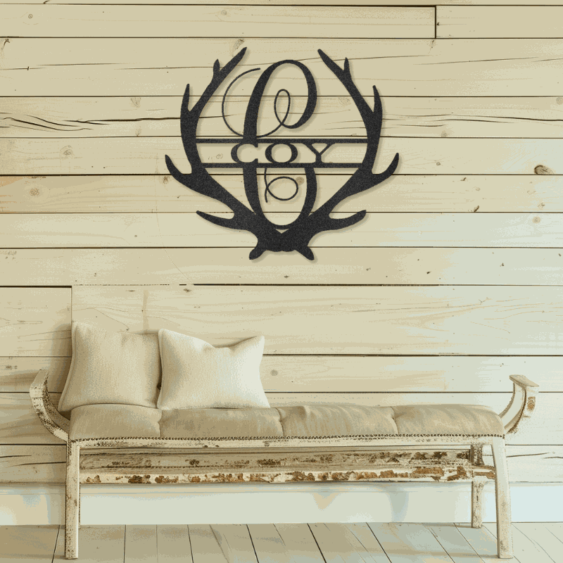 Antler Monogram customizable laser-cut steel sign hanging on wooden wall above rustic bench.