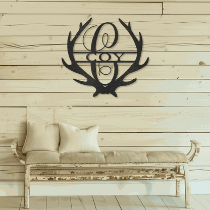 Antler Monogram customizable laser-cut steel sign hanging on wooden wall above rustic bench.