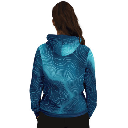 A person with long brown hair is wearing the Deep Blue Depth Map Hoodie, designed with an underwater contours pattern. The individual faces away from the camera against a black background.