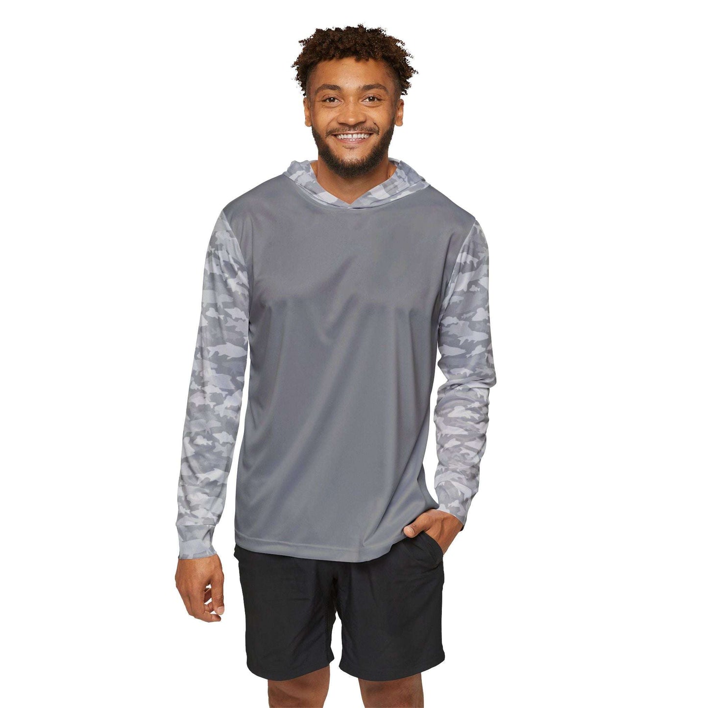 A smiling man stands against a white background, wearing the CastAway Camo Sun Protection Hoodie UPF +50 in Light Grey. The hoodie showcases camouflage-patterned sleeves and is made from moisture-wicking polyester, complementing his black shorts seamlessly.