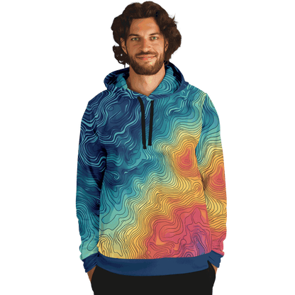 The Depth Explorer Pull Over Hoodie - Tri-Blend features a vibrant array of intricate, wavy line patterns in shades of blue, green, yellow, and red. These designs mimic underwater contours on a topographic map, giving the garment a textured and flowing look throughout. The ensemble includes the hood up and hands tucked into the front pocket.