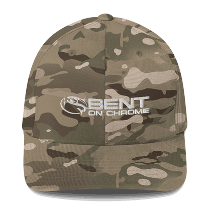 A camouflage athletic hat featuring the Bent on Chrome logo embroidered in white on the front. The cap has a structured design with a curved brim.