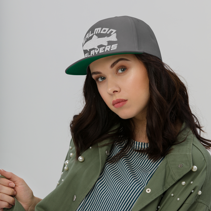 Salmon Slayers flat bill cap with green undervisor, high-profile fit, worn by a woman in a green jacket.