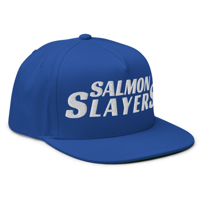 Flat bill cap in blue cotton twill displays "Salmon Slayers" embroidered in white on the front, featuring a convenient snapback closure, set against a black background.