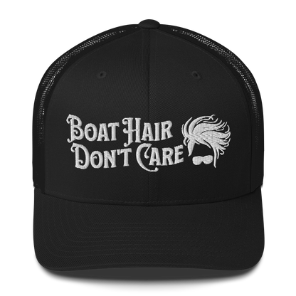 A Boat Hair, Don't Care - Trucker Style Fishing Cap with white mesh backing featuring the embroidered text "Boat Hair Don't Care" alongside a stylized illustration of hair blowing in the wind and a pair of sunglasses, making it the perfect fishing cap for your next adventure.