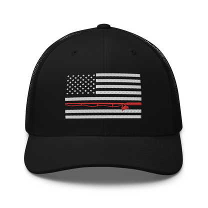 A black Fishing Flag Trucker Cap with an embroidered design of the American flag in white and gray. One of the horizontal stripes is red and features a silhouette of a bass fish. The flag design is centered on the front panel of this fishing enthusiasts hat.