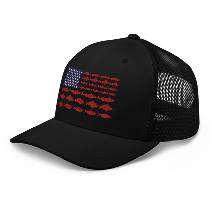 This Fishy Flag Trucker Cap is a black baseball cap featuring an American flag design made up of fish. The blue and white stars section is in the top left, while the red stripes are composed of small fish silhouettes, making it perfect for fishing enthusiasts.