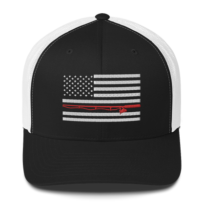 A black Fishing Flag Trucker Cap with an embroidered design of the American flag in white and gray. One of the horizontal stripes is red and features a silhouette of a bass fish. The flag design is centered on the front panel of this fishing enthusiasts hat.