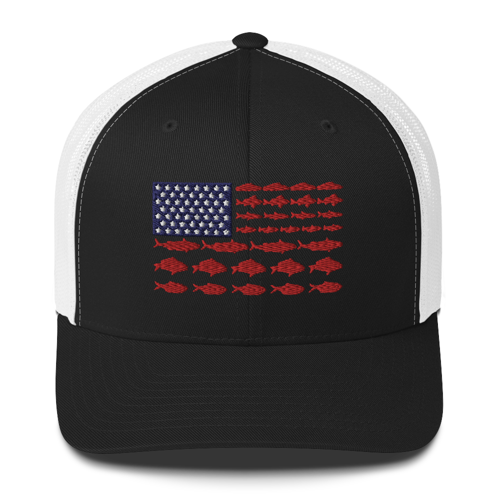 This Fishy Flag Trucker Cap is a black baseball cap featuring an American flag design made up of fish. The blue and white stars section is in the top left, while the red stripes are composed of small fish silhouettes, making it perfect for fishing enthusiasts.