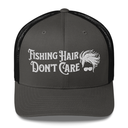 A black and white Fishing Hair, Don't Care - Trucker Style Fishing Cap with a curved brim and mesh back. The front of the cap features the embroidered text "Fishing Hair Don't Care" in white thread next to an image of stylized windblown hair and stylish sunglasses, perfect for fishing enthusiasts.