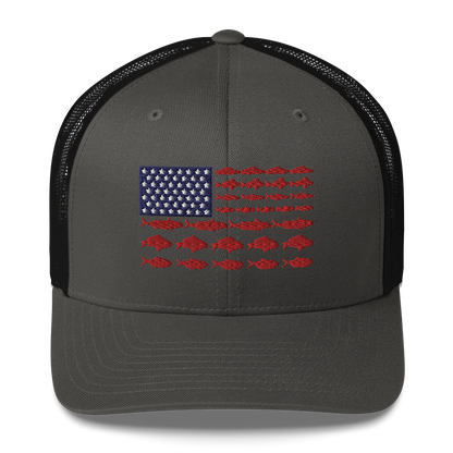 This Fishy Flag Trucker Cap is a black baseball cap featuring an American flag design made up of fish. The blue and white stars section is in the top left, while the red stripes are composed of small fish silhouettes, making it perfect for fishing enthusiasts.