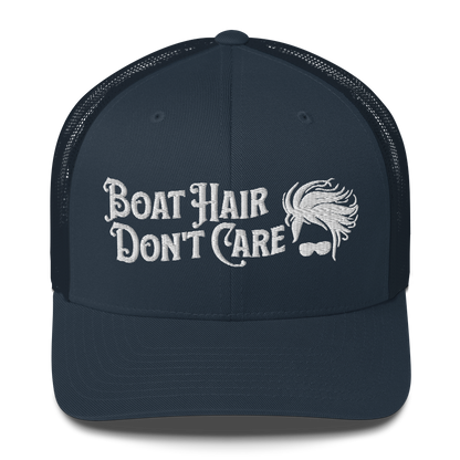 A Boat Hair, Don't Care - Trucker Style Fishing Cap with white mesh backing featuring the embroidered text "Boat Hair Don't Care" alongside a stylized illustration of hair blowing in the wind and a pair of sunglasses, making it the perfect fishing cap for your next adventure.