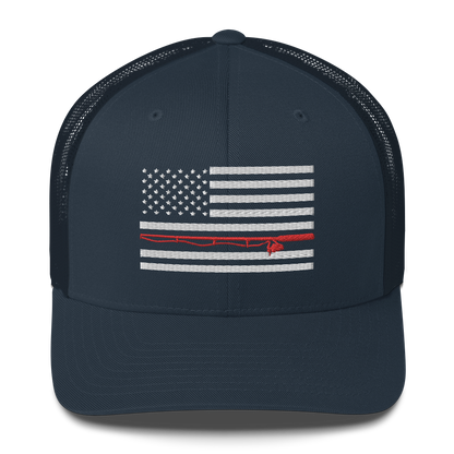 A black Fishing Flag Trucker Cap with an embroidered design of the American flag in white and gray. One of the horizontal stripes is red and features a silhouette of a bass fish. The flag design is centered on the front panel of this fishing enthusiasts hat.