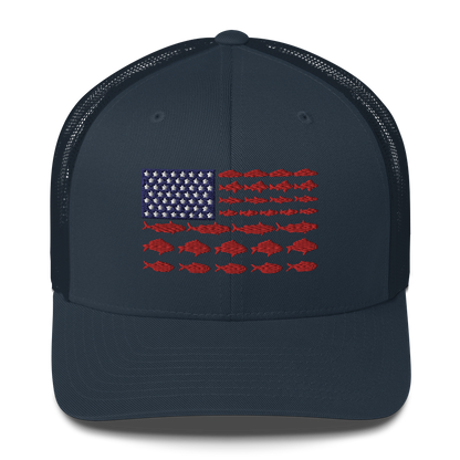 This Fishy Flag Trucker Cap is a black baseball cap featuring an American flag design made up of fish. The blue and white stars section is in the top left, while the red stripes are composed of small fish silhouettes, making it perfect for fishing enthusiasts.