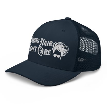 A black and white Fishing Hair, Don't Care - Trucker Style Fishing Cap with a curved brim and mesh back. The front of the cap features the embroidered text "Fishing Hair Don't Care" in white thread next to an image of stylized windblown hair and stylish sunglasses, perfect for fishing enthusiasts.