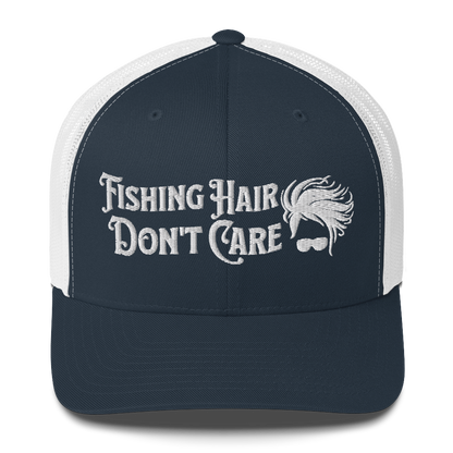 A black and white Fishing Hair, Don't Care - Trucker Style Fishing Cap with a curved brim and mesh back. The front of the cap features the embroidered text "Fishing Hair Don't Care" in white thread next to an image of stylized windblown hair and stylish sunglasses, perfect for fishing enthusiasts.