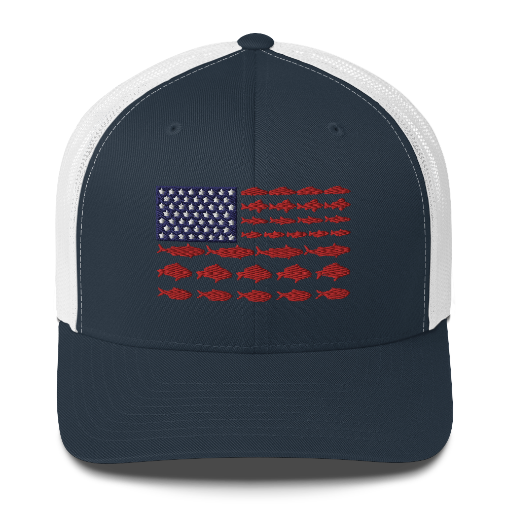 This Fishy Flag Trucker Cap is a black baseball cap featuring an American flag design made up of fish. The blue and white stars section is in the top left, while the red stripes are composed of small fish silhouettes, making it perfect for fishing enthusiasts.