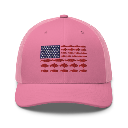 This Fishy Flag Trucker Cap is a black baseball cap featuring an American flag design made up of fish. The blue and white stars section is in the top left, while the red stripes are composed of small fish silhouettes, making it perfect for fishing enthusiasts.