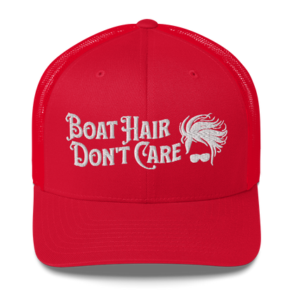 A Boat Hair, Don't Care - Trucker Style Fishing Cap with white mesh backing featuring the embroidered text "Boat Hair Don't Care" alongside a stylized illustration of hair blowing in the wind and a pair of sunglasses, making it the perfect fishing cap for your next adventure.