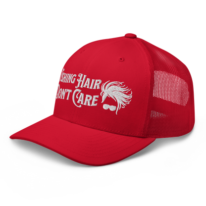 A black and white Fishing Hair, Don't Care - Trucker Style Fishing Cap with a curved brim and mesh back. The front of the cap features the embroidered text "Fishing Hair Don't Care" in white thread next to an image of stylized windblown hair and stylish sunglasses, perfect for fishing enthusiasts.