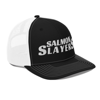 A black and gray mesh Salmon Slayers - Richardson 112 - trucker cap with the words "salmon slayers" embroidered in bold, white letters across the front.