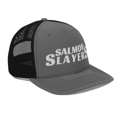 A black and gray mesh Salmon Slayers - Richardson 112 - trucker cap with the words "salmon slayers" embroidered in bold, white letters across the front.